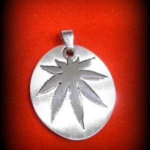 висулка листо от канабис в плочка от медицинска стомана на червен фон