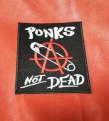 Квадратна черна рок нашивка Punk’s Not Dead с червен символ за анархия и безопасна игла