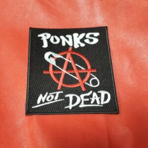 Квадратна черна рок нашивка Punk’s Not Dead с червен символ за анархия и безопасна игла