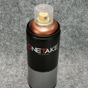 Спрей боя бронз мат One Take 400ml с прозрачна капачка, поставен върху сива повърхност.